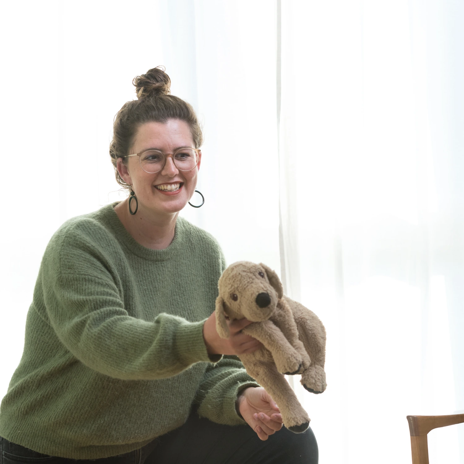 Dorothea Singer hält einen Hund-Kuscheltier in ihrer Praxis Soma & Raum Stuttgart